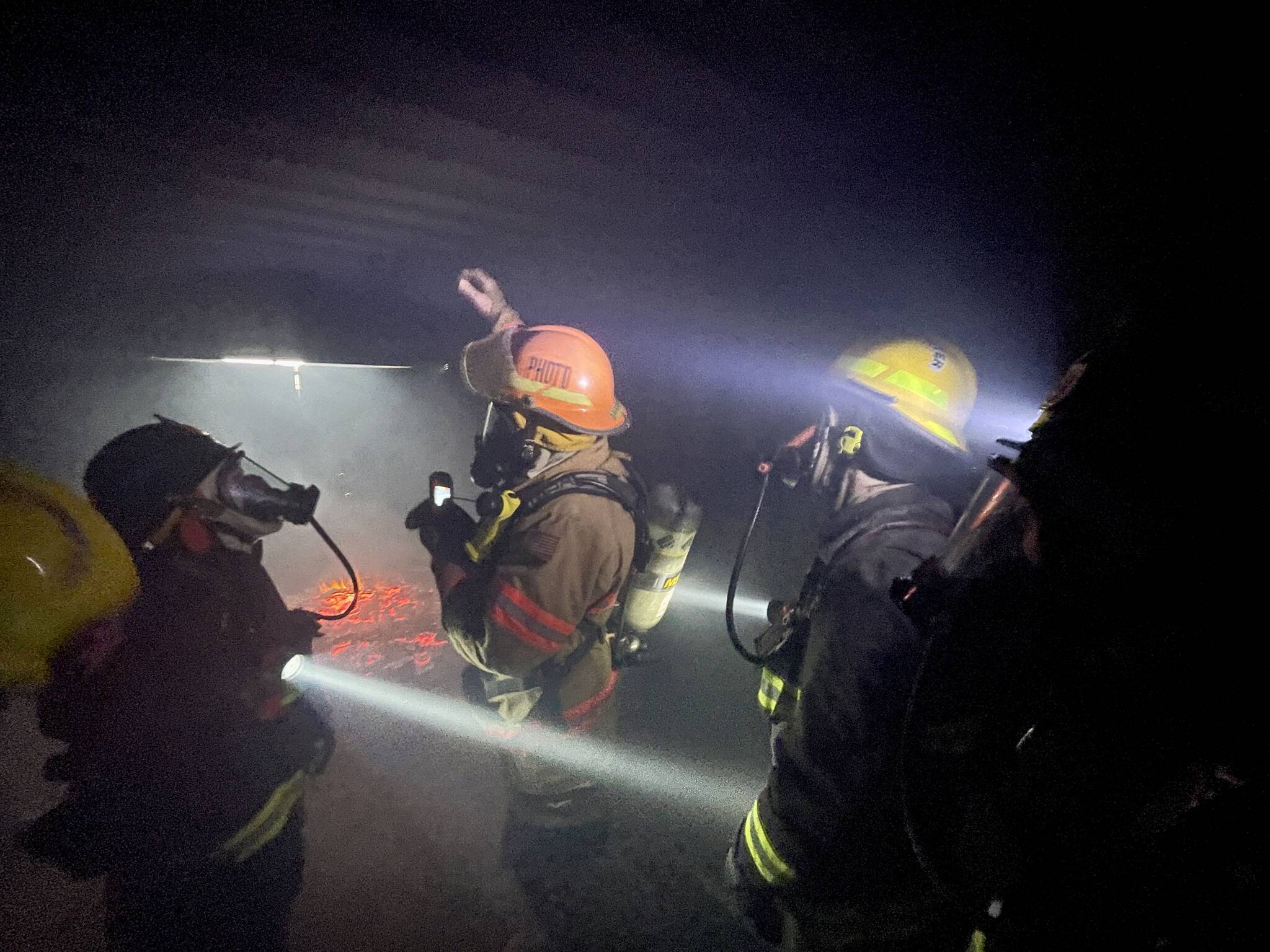 Chief Dennis Benn of the South Beach Regional Fire Authority, hand raised, demonstrates thermal layering from fire in an enclosed space during a firefighter academy in Westport on Feb. 18. (Michael S. Lockett / The Daily World)