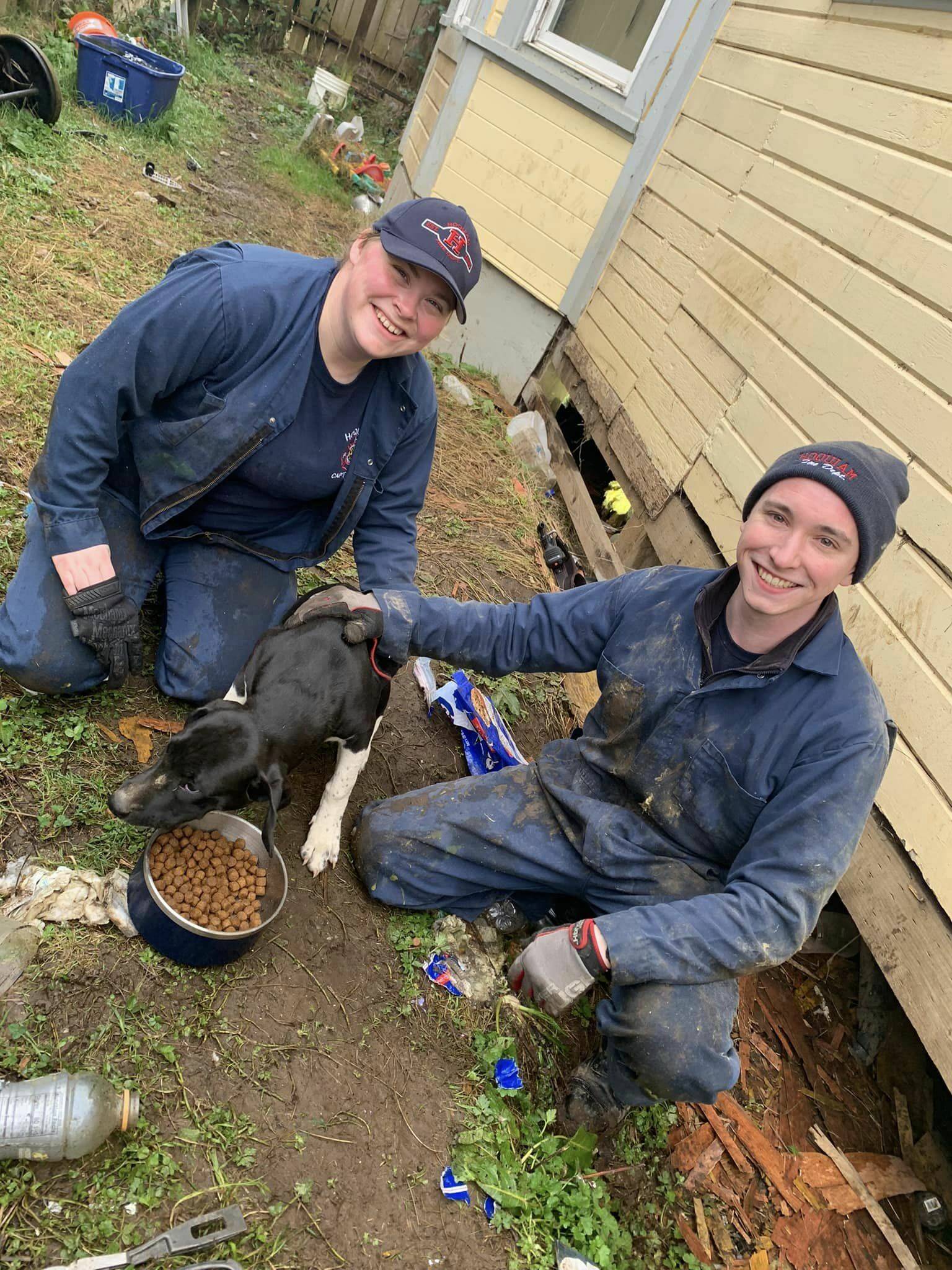 Courtesy photo / Hoquiam Fire Department
Hoquiam firefighter Eli Fox, right, and Capt. Larissa Rohr, left, were able to free Hero, the puppy, center, after he became stuck in a crawlspace.