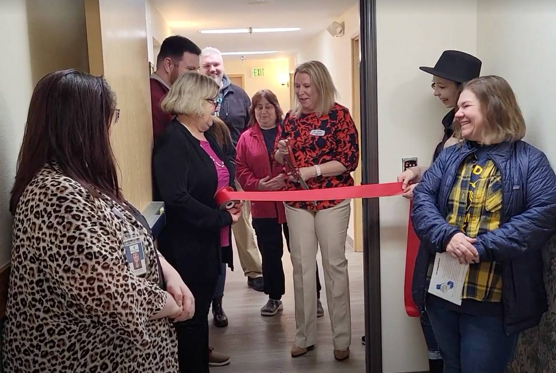 Photo Courtesy of GGHI
Jen Pretty, vice president of operations for Channel Point Village (holding scissors), prepares to cut the ceremonial ribbon on Thursday, March 23, to unveil a newly remodeled memory care wing. The ceremony was planned in coordination with Greater Grays Harbor Inc.