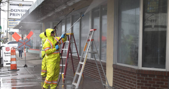 Matthew N. Wells / The Daily World
Sean McAllister and Max Acosta, public works employees for the city of Aberdeen, pressure wash the outside of 118 W. Wishkah St., the future home of the Aberdeen Museum of History. Staff also removed the old Salvation Army sign that hanged above the awning.