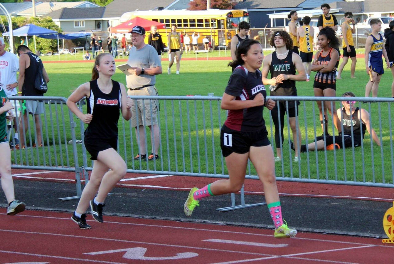 PHOTO BY AARON ANDERSON Ocosta’s Rebekah Stone, right, leads Raymond’s Genevieve Sarich during the 3200-meter race at the 2B District 4 Championships on Friday in Chehalis. Stone qualified for the state meet in three individual events.