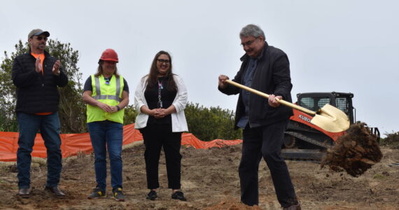 Ocean Shores Mayor Jon Martin, right, scoops a pile of dirt near the Chance A La Mer beach entrance on Friday, June 16, to signal the start of construction on the High Dune Trail. Martin is accompanied from left, by City Administrator Scott Andersen, Project Manager Becky Leach and Grant Coordinator Sarah Bisson. (Clayton Franke / The Daily World)