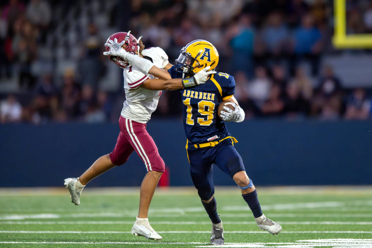 PHOTO BY FOREST WORGUM Aberdeen running back Aidan Watkins (19) stiff-arms Hoquiam defensive back Javonni Koth during the Bobcats’ 36-0 win on Friday at Stewart Field in Aberdeen. Watkins rushed for 110 yards and four touchdowns in the victory.