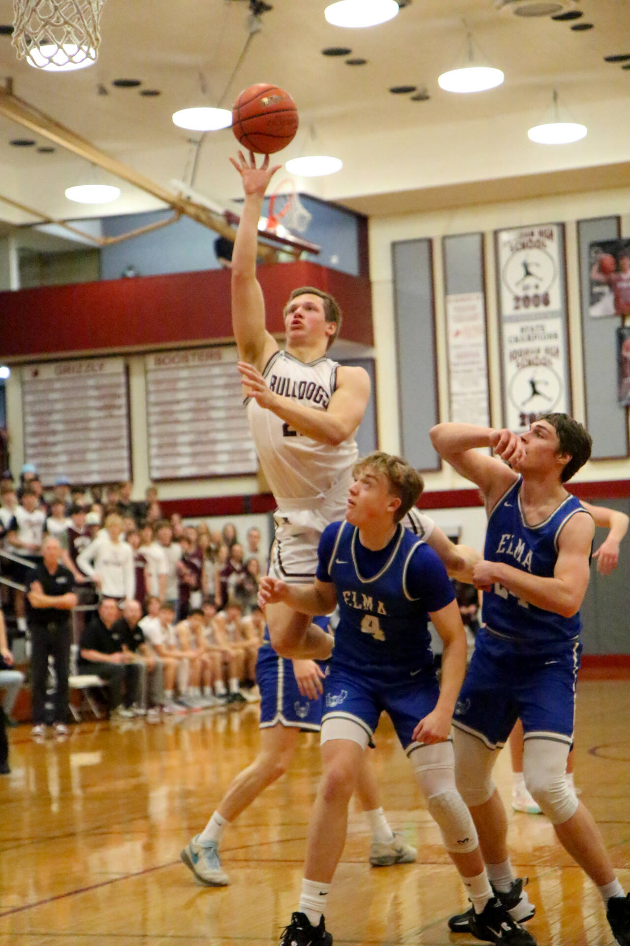 PHOTO BY FOREST WORGUM Montesano senior Tyce Peterson, top, puts up a shot against Elma’s Grant Vessey (4) and Carter Studer during the Bulldogs’ 63-54 win in the 1A District 4 third-place game on Saturday at Hoquiam High School.