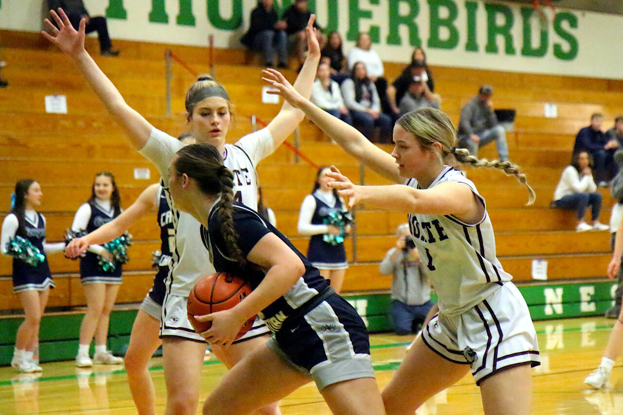 RYAN SPARKS | THE DAILY WORLD Montesano’s Jillie Dalan, left, and Josie Forster, right, surround Cascade Christian’s Marissa Linkem during the Bulldogs’ 41-25 win in a 1A State first-round game on Saturday at Tumwater High School.