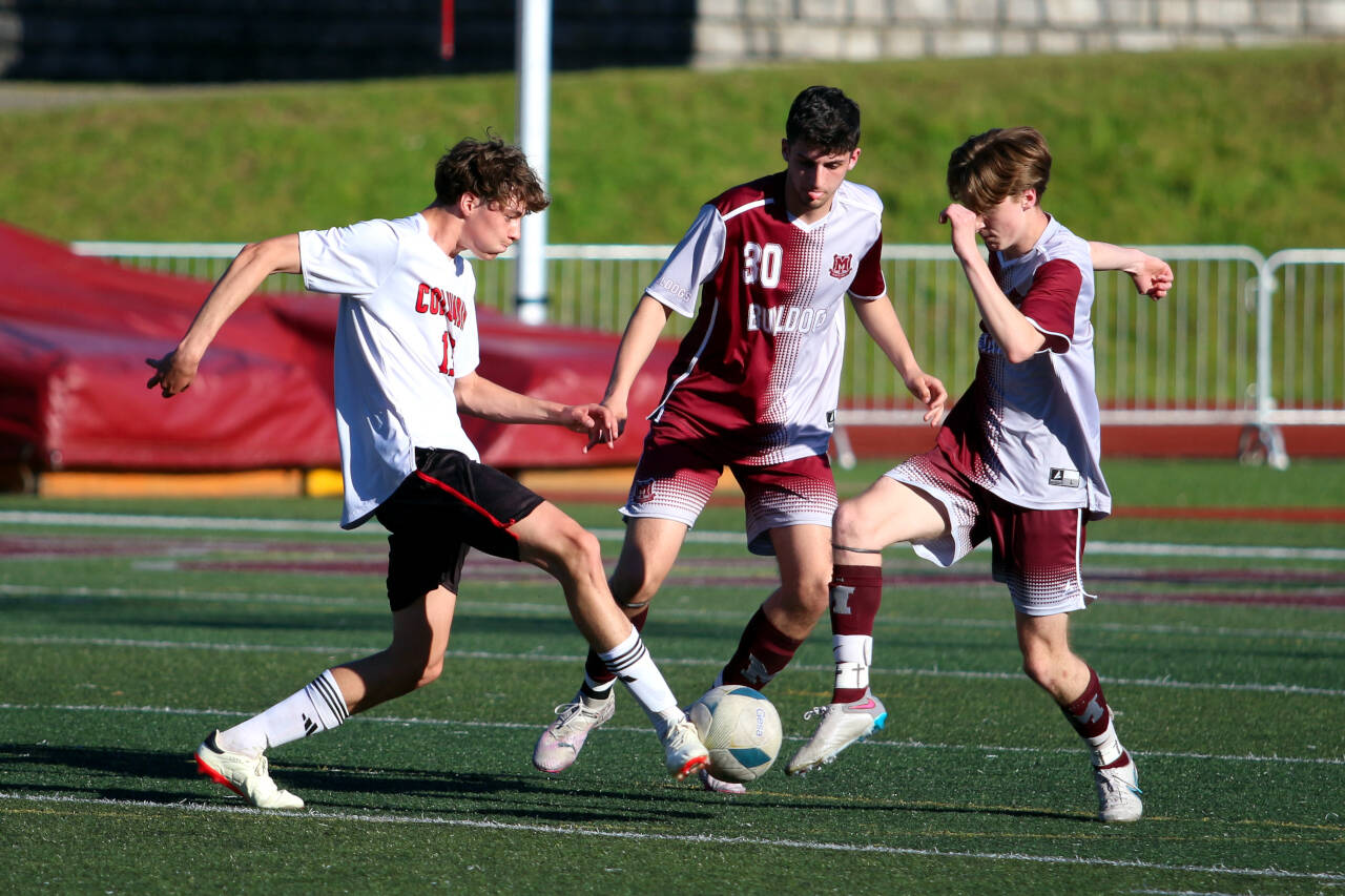 RYAN SPARKS | THE DAILY WORLD Montesano’s James Busche (right) and Spencer Lovell (30) defend against Columbia (White Salmon) midfielder Matthew Miller during the Bulldogs’ 2-0 loss in a 1A District 4 semifinal game on Thursday in Montesano.