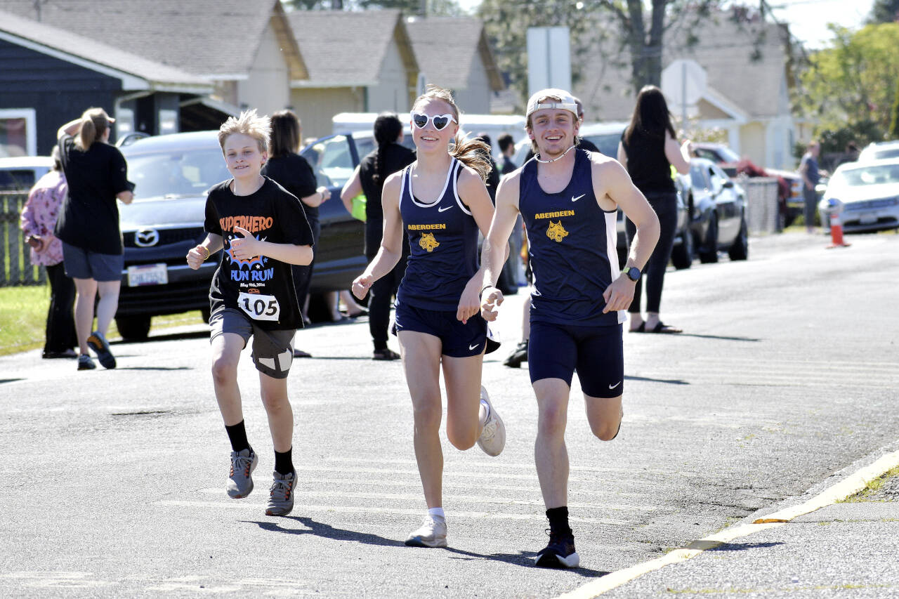 PHOTO BY RACHEL ROSE Members of the Aberdeen Bobcats track and field team run with a participant at the AJ West Fun Run on Friday in Aberdeen.