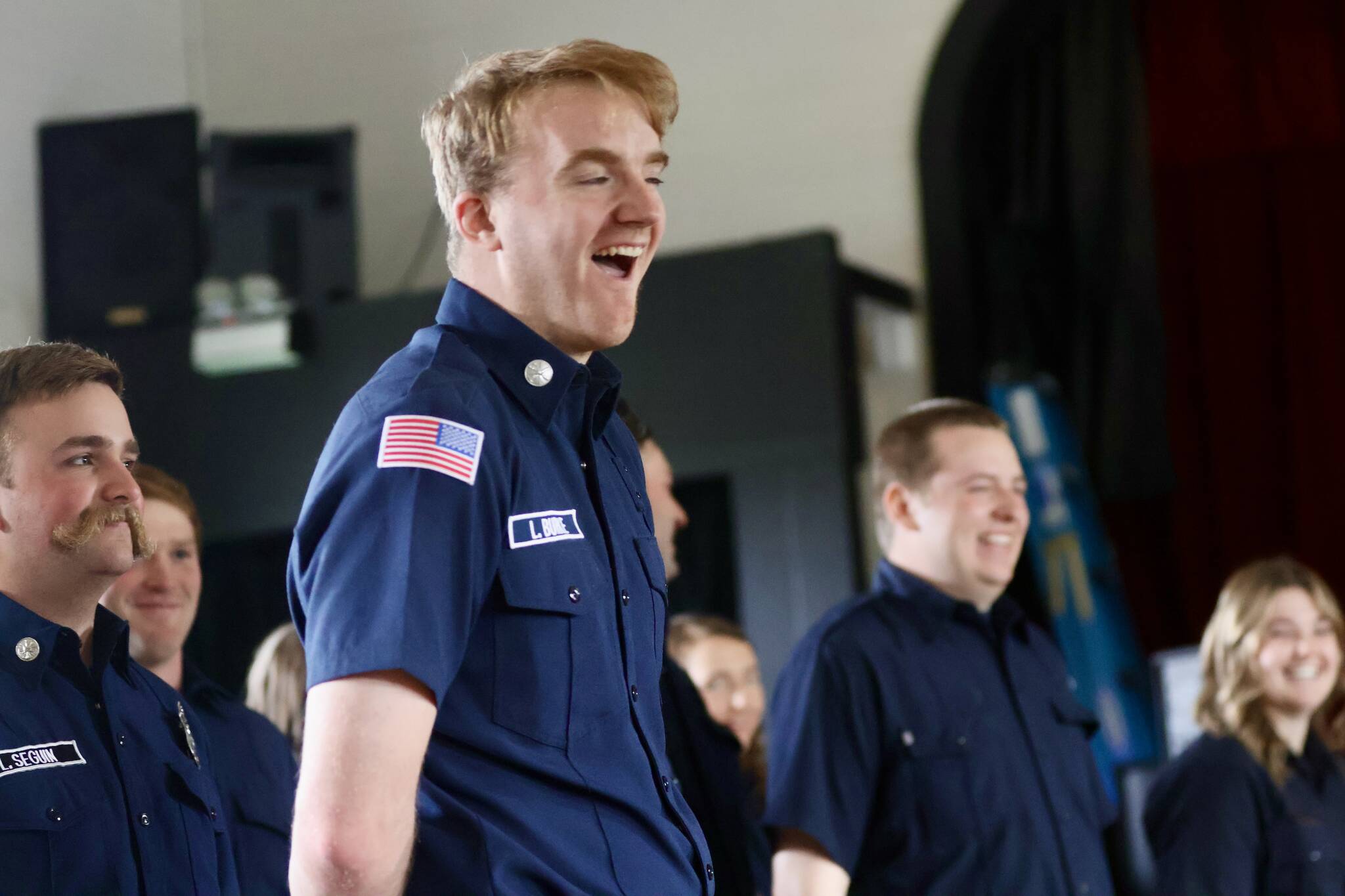 Members of the county fire academy, with Liam Burke of District 7 in the foreground, celebrate during the graduation ceremony. (Michael S. Lockett / The Daily World)