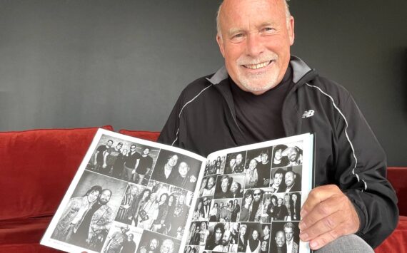 Matthew N. Wells / The Daily World
Darrell Westmoreland, a renowned music photographer who has led a career for other photographers to dream about, shows off a couple pages from his book “Snap, Click Flash: All Access Pass,” as he spoke to The Daily World about a bit of his career and the people, like Stan Foreman, who helped him along the way. Despite his success, Westmoreland remains grounded and humble.