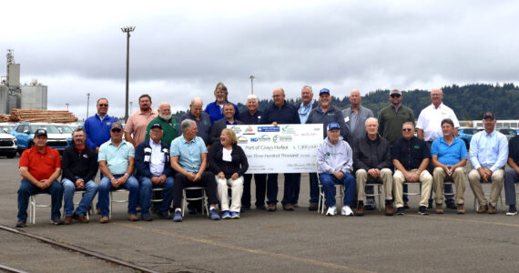 Officials from the Port of Grays Harbor and various soybean farming and transport groups from across the Midwest pose with a ceremonial check for $1.3 million on Tuesday in honor of the partnership. (Michael S. Lockett / The Daily World)