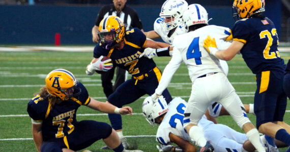 RYAN SPARKS / THE DAILY WORLD Aberdeen’s Legend Vessey (2) is pursued by the Olympic Defense during the Bobcats’ 20-6 loss on Friday at Stewart Field in Aberdeen.