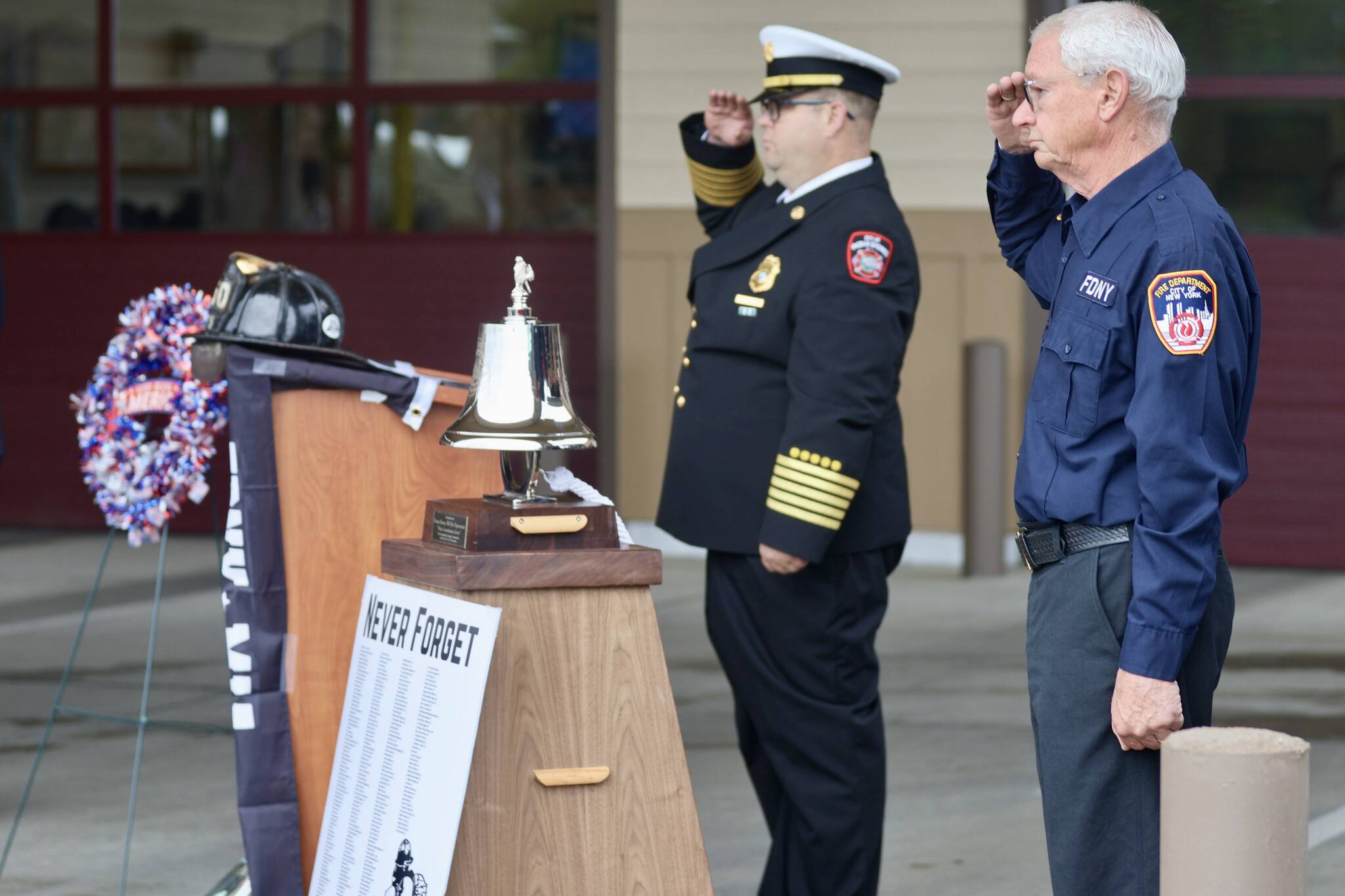 Chief Brian Ritter and Assistant Chief Mike Mandella of Ocean Shores Fire Department salute during a 9/11 ceremony. (Michael S. Lockett / The Daily World)