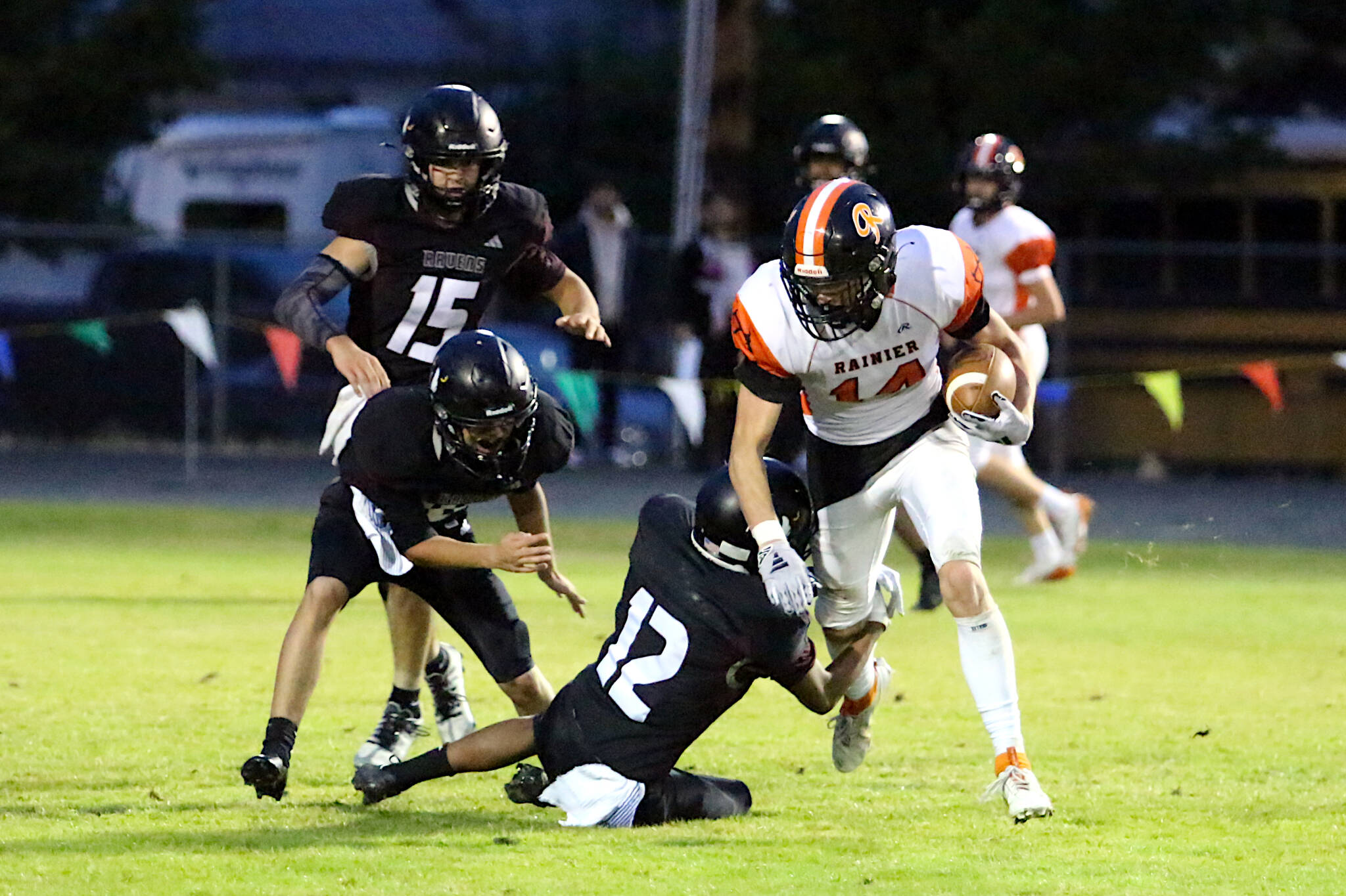 RYAN SPARKS | THE DAILY WORLD Raymond-South Bend defender Adam Mora (12) tackles Rainier receiver Hunter Howell (14) during the Ravens’ 43-34 loss on Friday at Raymond High School.