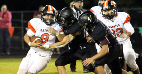 RYAN SPARKS | THE DAILY WORLD Rainier running back Dorien Cano (8) is tackled by Raymond-South Bend’s Isaac Schlueter (right) and Chris Banker during the Ravens’ 43-34 loss on Friday in Raymond.