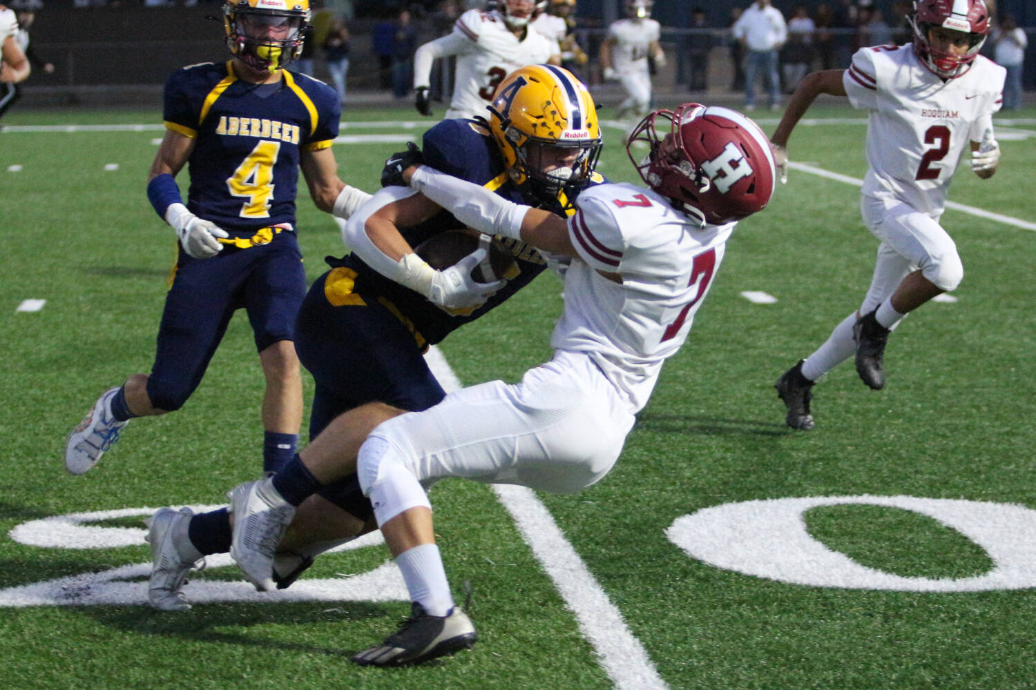 RYAN SPARKS | THE DAILY WORLD Aberdeen running back Micah Schroeder (middle) runs over Hoquiam defender Andrew Le while Bobcats receiver Adonis Hammonds (4) trails the play during Aberdeen’s 34-9 win on Friday at Stewart Field in Aberdeen.