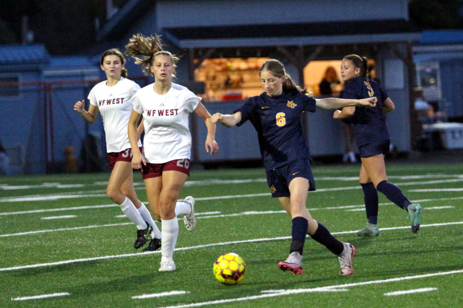 RYAN SPARKS | THE DAILY WORLD Aberdeen freshman midfielder Kennedy Kolodzie (6) passes the ball while being defended by W.F. West’s Elizabeth Mittage (26) during the Bobcats’ 2-0 loss on Thursday at Stewart Field in Aberdeen.