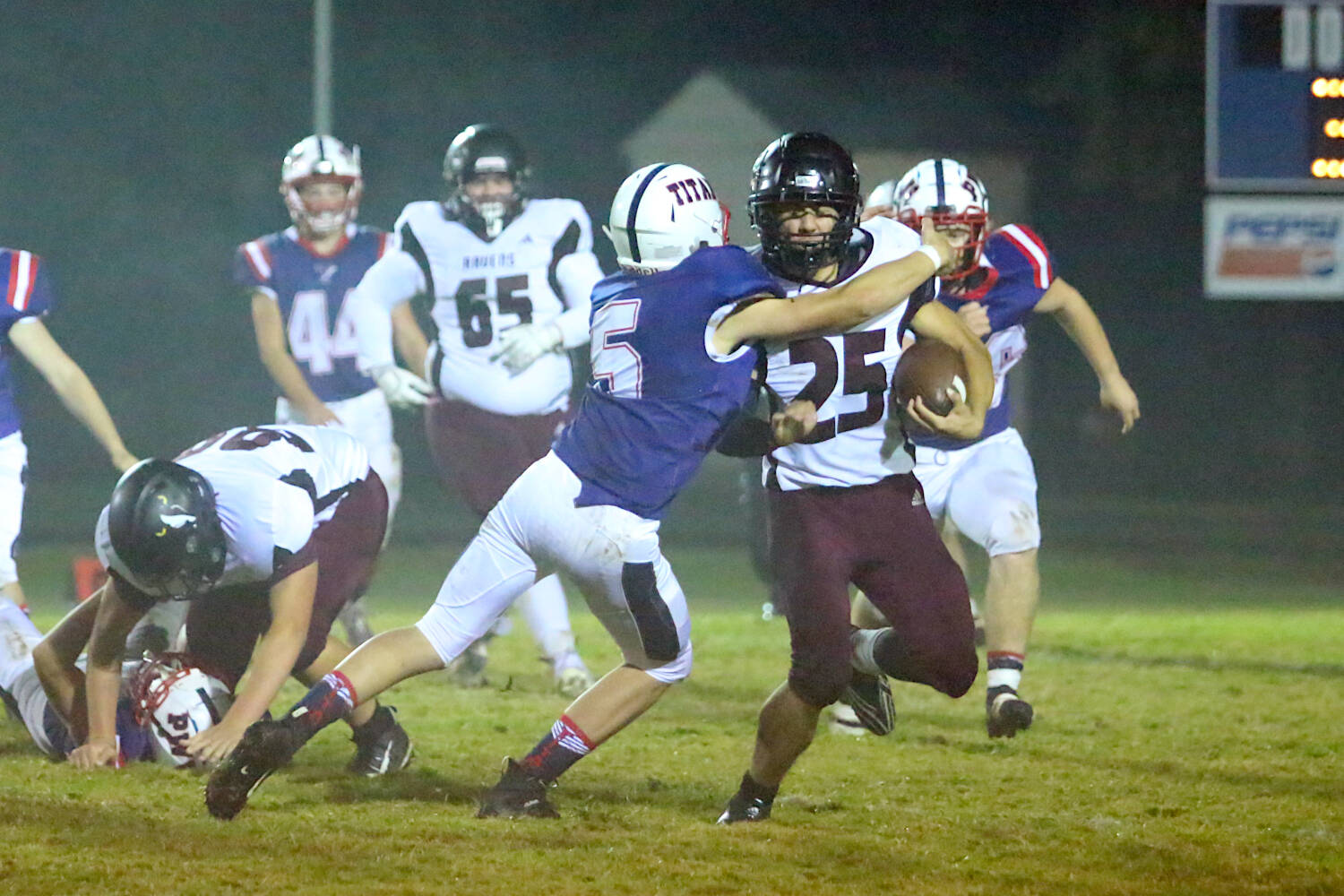 RYAN SPARKS | THE DAILY WORLD Raymond-South Bend running back Chris Banker (25) is tackled by Pe Ell-Willapa Valley defensive back Ryan Clements during the Titans’ 53-14 win on Friday at Crogstad Field in Menlo.