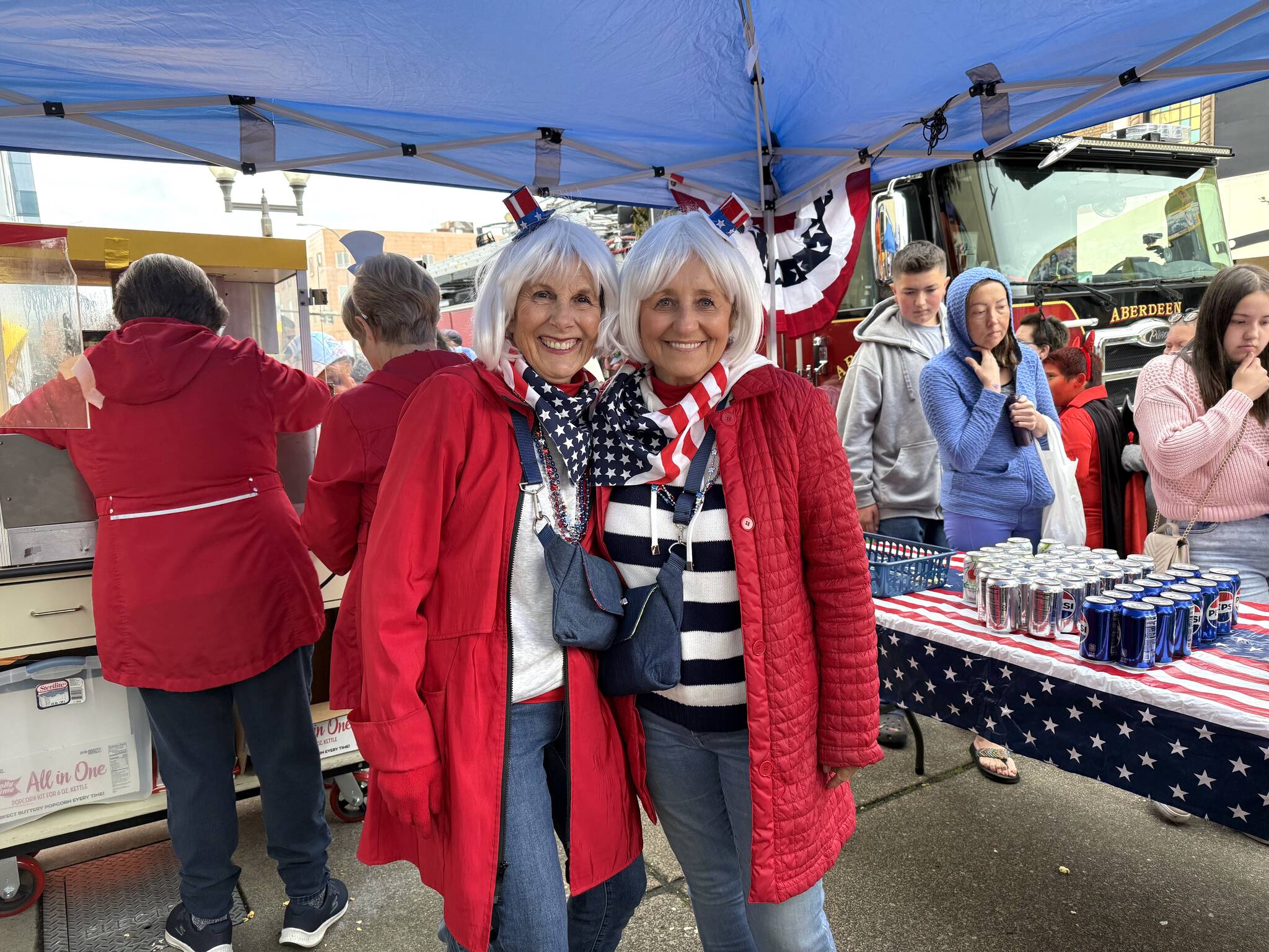 Bette Worth, left, and Bobbi McCracken were having a blast and working hard with other volunteers at the candy, pop and popcorn station for Downtown Aberdeen Association. (Matthew N. Wells / The Daily World)