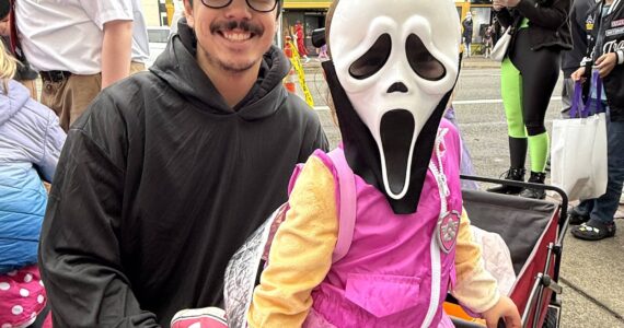 Rory Nguyen and his daughter Paisley walk around Downtown Aberdeen in search of candy and fun. Paisley was dressed in both "Ghost Face" from the Scream movies and a character from Paw Patrol. (Matthew N. Wells / The Daily World)