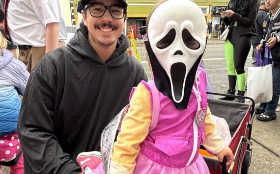 Rory Nguyen and his daughter Paisley walk around Downtown Aberdeen in search of candy and fun. Paisley was dressed in both "Ghost Face" from the Scream movies and a character from Paw Patrol. (Matthew N. Wells / The Daily World)