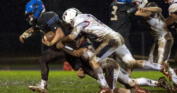 KODY CHRISTEN | THE CHRONICLE Adna’s Luke Mohney (left) is tackled by Pe Ell-Willapa Valley’s Cody Mican (10) during the Titans’ 14-0 loss on Thursday in Adna.