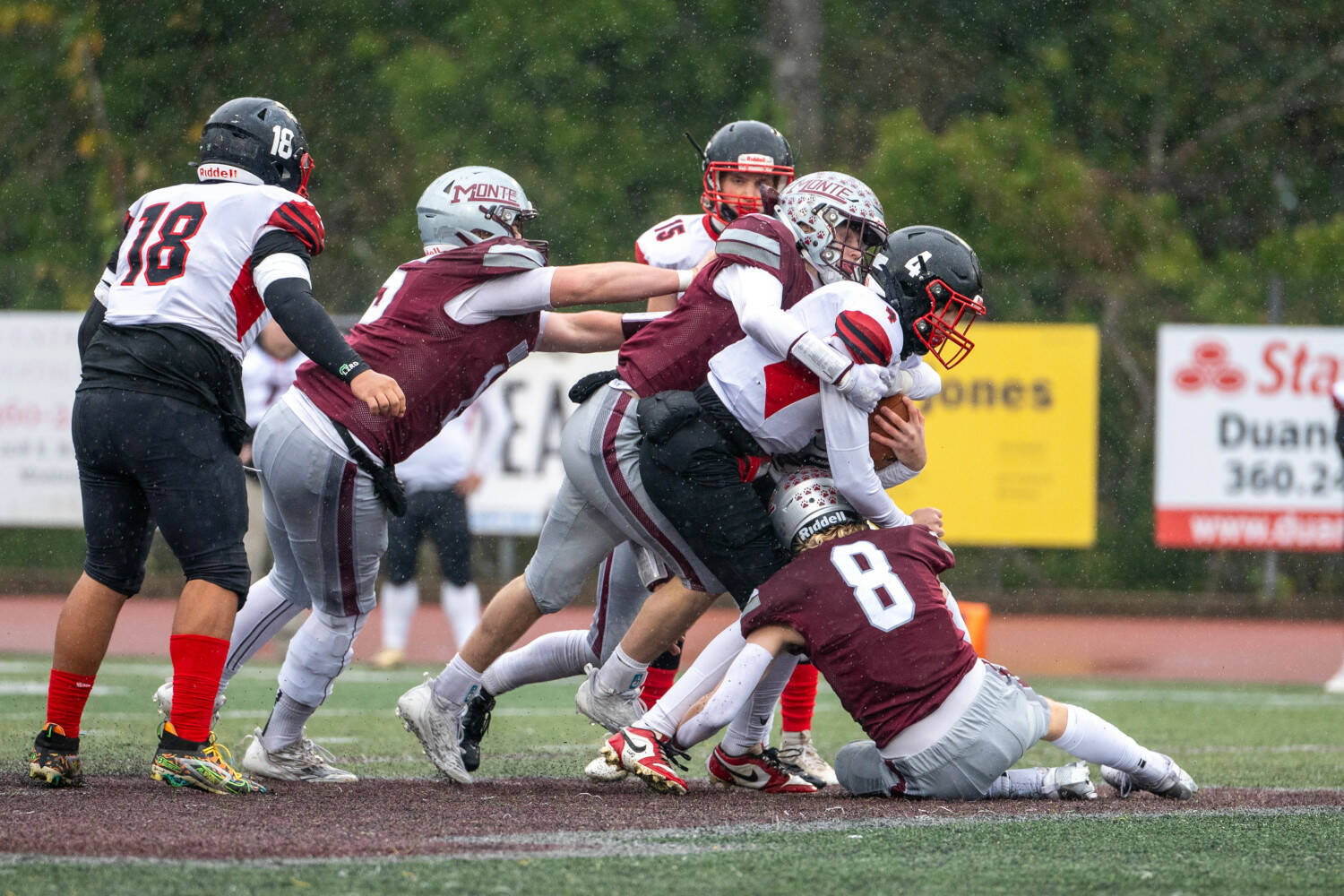 PHOTO BY FOREST WORGUM Montesano defenders Gabe Pyhala (middle), Mason Fry (8) and Felix Romero tackle Omak quarterback Teagen Mullin during the Bulldogs’ 31-7 victory in a 1A State Tournament playoff game on Saturday in Montesano.