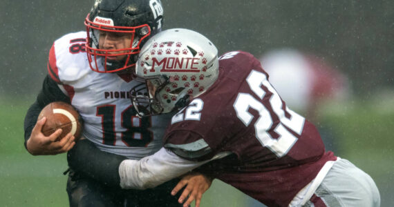 PHOTO BY FOREST WORGUM Montesano defender Ashton McKinney (22) lays a hit on Omak tight end Payton Smith during the Bulldogs’ 31-7 win in a 1A State Tournament playoff game on Saturday at Montesano High School.