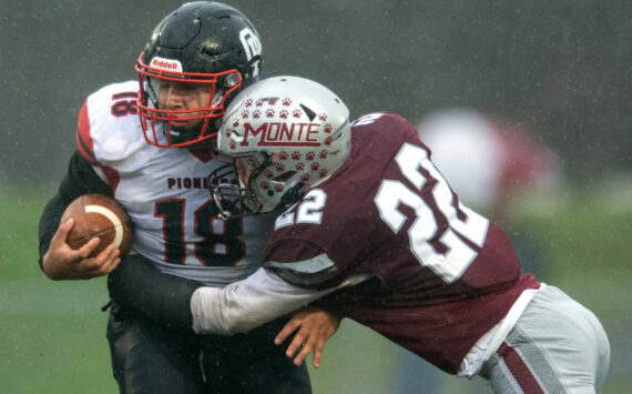 PHOTO BY FOREST WORGUM Montesano defender Ashton McKinney (22) lays a hit on Omak tight end Payton Smith during the Bulldogs’ 31-7 win in a 1A State Tournament playoff game on Saturday at Montesano High School.