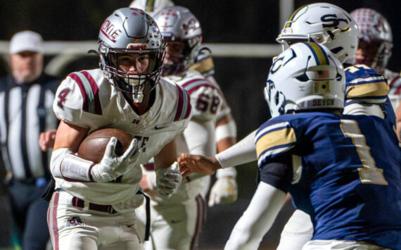 PHOTO BY FOREST WORGUM Montesano’s Zach Timmons (4) carries the football against the Seton Catholic defense during the Bulldogs’ 35-14 loss in a 1A State semifinal game on Saturday in Vancouver.