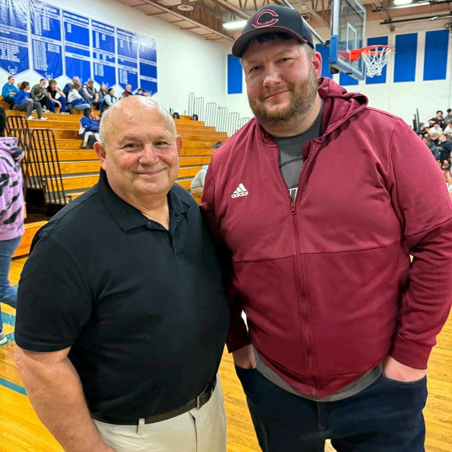 PHOTO BY SHAWNIE RAKEVICH Former Elma wrestling greats Rick Rakevich (left) and Jamie Rakevich pose for a photo during an Elma dual meet against W.F. West on Wednesday in Elma. The father-son duo were honored at the meet as 2024 Elma Athletics Hall of Fame inductees.