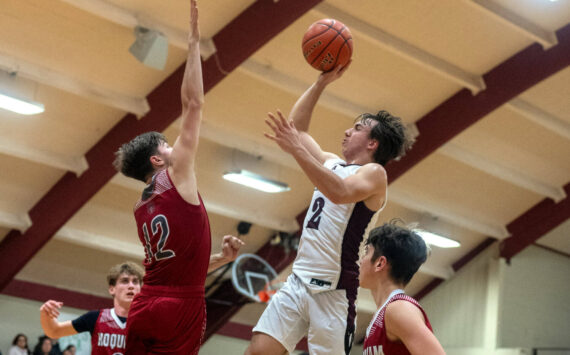 PHOTO BY FOREST WORGUM Raymond-South Bend’s Chris Banker (2) puts up a shot against Hoquiam’s Tage Dayton during the Grizzlies’ 57-44 win on Saturday at South Bend High School.