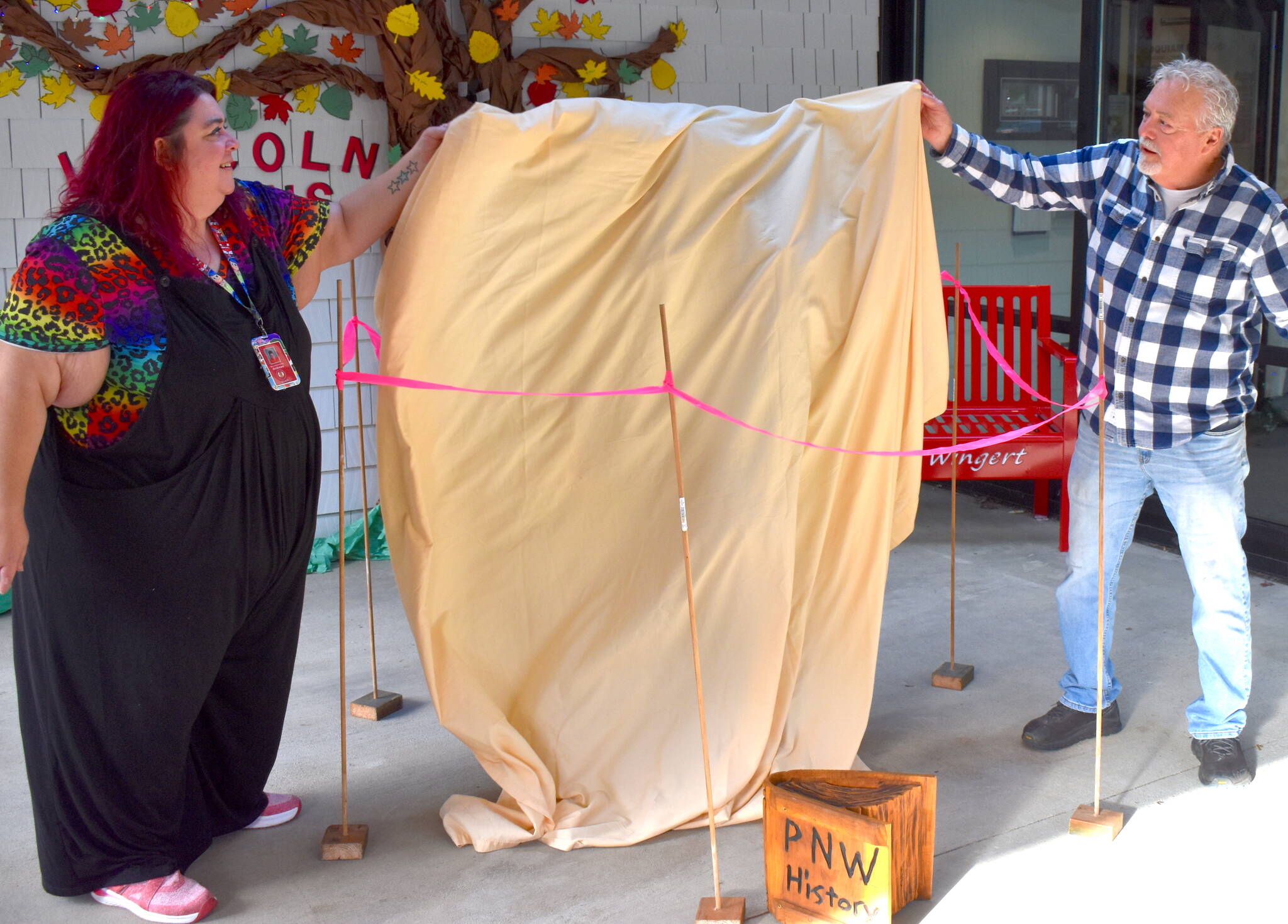 Lincoln Elementary School 5th grade teacher Andrea Andrews and her father, Jim Andrews, get ready to unveil a Bigfoot statue.