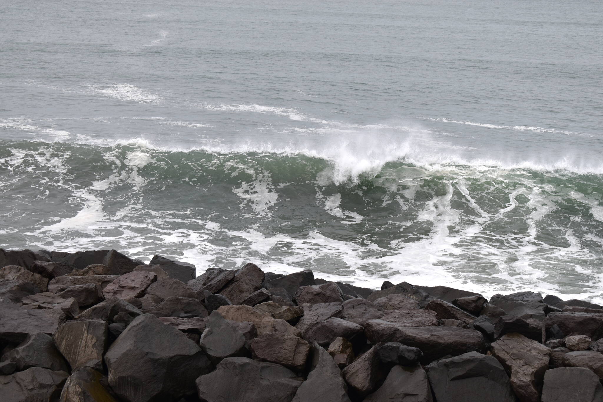 A wave breaks against the sea wall in Westport.